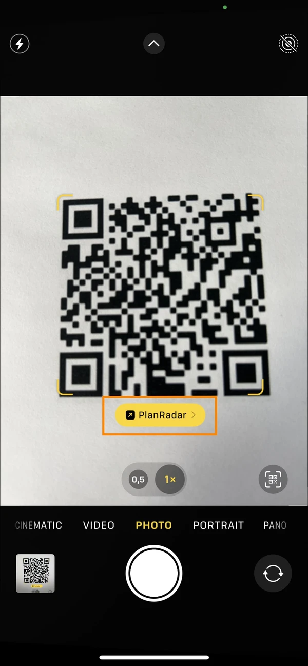 iPhone camera app with a scanned QR code and the PlanRadar button highlighted below it