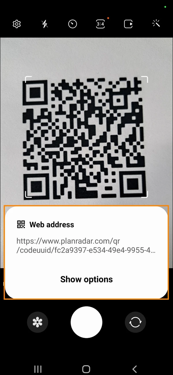 Android camera app showing the scanned QR code’s web address, with Show options below it